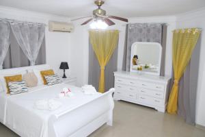 Apartamento BOUTIQUE con encanto en Juan Dolio-Metro Country Club-CON PISCINA, SEGURIDAD PRIVADA, ENERGIA 24-7, CAMPO DE GOLF Y TENIS房間的床
