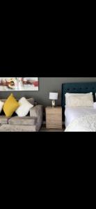 a bedroom with two beds and a table with a lamp at Menylyn Maine Residences Trilogy 913 in Pretoria
