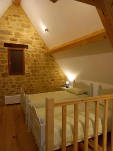 een slaapkamer met een bed in een bakstenen muur bij Maison de la Ruelle, vue sur les toits de Domme in Domme