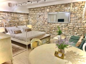 a bedroom with a bed and a stone wall at CUORE DI ROVIGNO in Rovinj