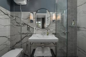 bagno con lavandino e specchio di No 39 Svolou Suites a Salonicco