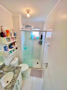 a bathroom with a shower and a toilet and a sink at Lindo apto na Enseada - Guarujá - 8 min da praia in Guarujá