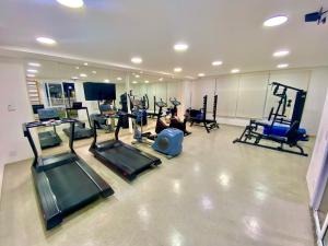 a man exercising in a gym with several machines at Lindo apto na Enseada - Guarujá - 8 min da praia in Guarujá