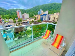 two chairs on a balcony with a view of a city at Lindo apto na Enseada - Guarujá - 8 min da praia in Guarujá