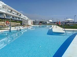 een groot zwembad met blauw water in een gebouw bij Via Celere 2335 Golf & Sea view in Casares