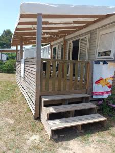 a mobile home with a porch and a deck at Mobil home climatisé chez Mickaël et Laëtitia in Narbonne