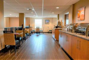 a restaurant with a bar and some tables and chairs at Comfort Inn & Suites Patriots Point in Charleston