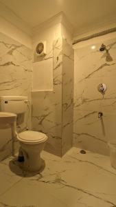 een witte badkamer met een toilet en een douche bij ZEKE HOTELS in Bangalore