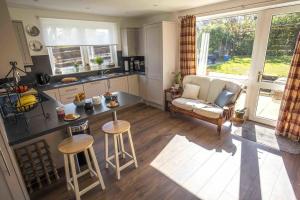 una cucina e un soggiorno con un divano e un tavolo di Douglas Cottage - Seasgair Lodges a Boat of Garten