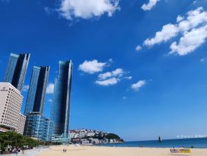a view of a beach with tall buildings at Haeundae Bona Travel in Busan
