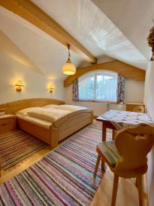 a bedroom with a large bed and a table at Appartements Hollaus in Gerlos