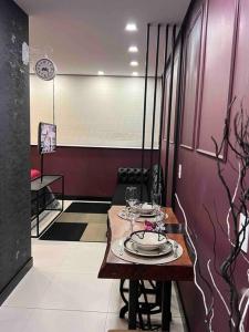 uma sala de jantar com uma mesa com pratos e copos de vinho em Apartamento Luxo Estiloso em Bento Gonçalves