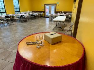 a table with wine glasses and a box on it at Los Fresnos Inn and Suites in Los Fresnos