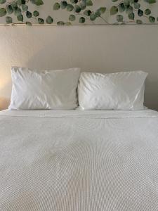 zwei Kissen auf einem weißen Bett in der Unterkunft Beautiful Room Near Disney/Universal & I-Drive in Kissimmee