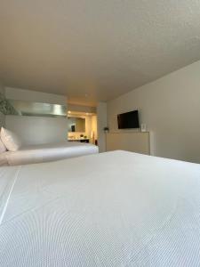 a large white bed in a room with a television at Beautiful Room Near Disney/Universal & I-Drive in Kissimmee