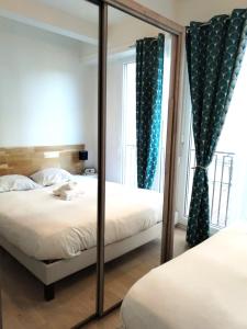 espejo en un dormitorio con 2 camas y ventana en Le Palais -Idéal Couple- Terrasse Hypercentre, en Pau