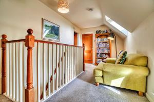 a living room with a staircase and a chair at Finest Retreats - Gag Barn in Ashbourne