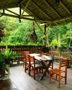 a patio with a table and chairs on a deck at Cabana dos Sonhos na Serra SC in Rancho Queimado