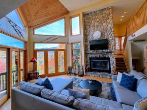CR16 Ski-in/Out luxury home mountain views Bretton Woods في بريتون وودز: غرفة معيشة مع أريكة ومدفأة
