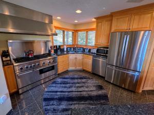 a kitchen with stainless steel appliances and wooden cabinets at CR16 Ski-in/Out luxury home mountain views Bretton Woods in Bretton Woods