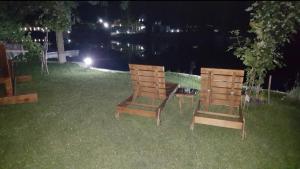 twee houten stoelen in het gras 's nachts bij House De Luxe in Bihać