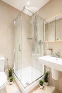 a bathroom with a shower and a toilet and a sink at Beaufort Gardens Apartment in Knightsbridge in London