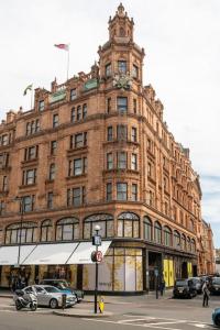 a large brick building with cars parked in front of it at Beaufort Gardens Apartment in Knightsbridge in London