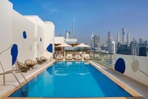 una piscina en la azotea de un edificio con vistas al perfil urbano en The First Collection Waterfront en Dubái