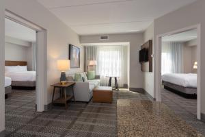 una camera d'albergo con due letti e un soggiorno di Staybridge Suites Buffalo, an IHG Hotel a Buffalo