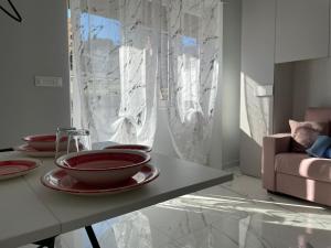 einen Tisch mit Tellern und Schüsseln im Wohnzimmer in der Unterkunft Cuore e Sole - Attico Monolocale con Parcheggio Privato A 5 minuti dal centro in Sanremo