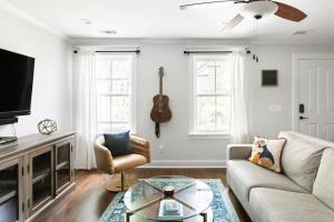 sala de estar con sofá, mesa de centro y guitarra en Downtown Liberty Garden Home, en Savannah