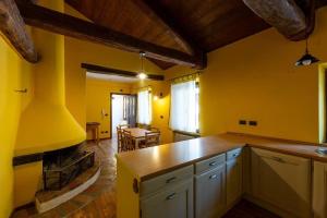 uma cozinha com paredes amarelas e um balcão em Relais Castel d'Emilio – Casa ARANCIO em Cassero