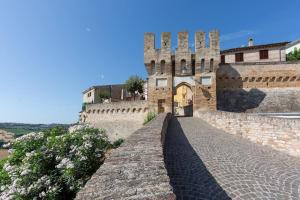 um edifício com uma torre e uma parede de tijolos em Relais Castel d'Emilio – Casa ARANCIO em Cassero