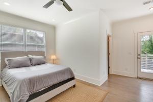 een witte slaapkamer met een bed en een raam bij ATL Home 2 Mi to Downtown Covered Deck and Backyard in Atlanta