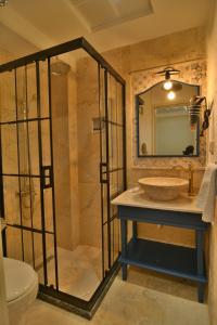 a bathroom with a shower and a sink and a mirror at SUR PALACE OTEL in Diyarbakır