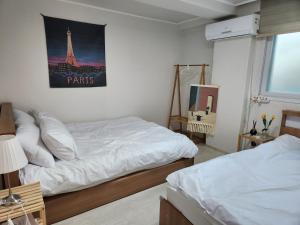 a bedroom with two beds and a picture of the eiffel tower at The Shim Anam 3rooms late check in-out in Seoul