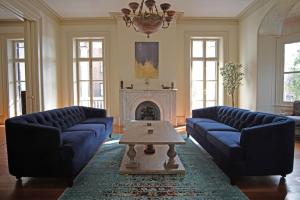 a living room with two blue couches and a fireplace at 8BR Historic Hamilton House in Savannah