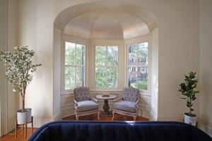 two chairs and a table in a room with windows at 8BR Historic Hamilton House in Savannah