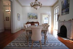 a dining room with a table and chairs and a fireplace at 8BR Historic Hamilton House in Savannah