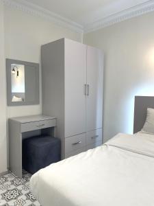 a white bedroom with a bed and a dresser and a mirror at Royal Pera Taksim in Istanbul