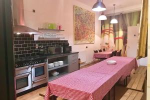 a kitchen with a table with a pink table cloth at higgihaus #107 Sleeps up to 22 Hens Stags Rugby in Cardiff