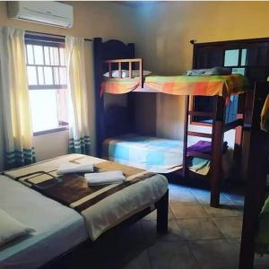 a bedroom with two bunk beds and a table at Green House Jabaquara in Paraty