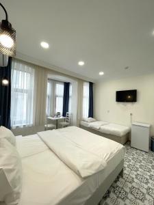 a bedroom with two beds and a tv on the wall at Royal Pera Taksim in Istanbul