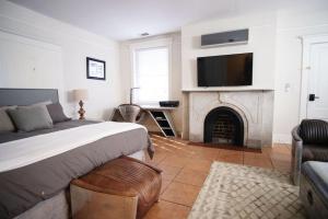 a bedroom with a bed and a fireplace with a tv at Pasadena Suite at Hamilton in Savannah