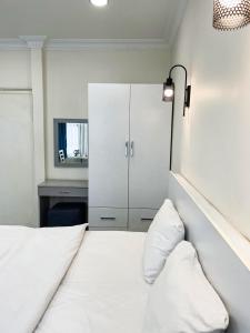 Royal Pera Taksim في إسطنبول: غرفة نوم مع سرير أبيض وخزانة