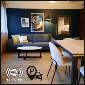 uma sala de estar com um sofá e uma mesa em Le Blue Moon - 50m centre historique - parking privatif em Sarlat-la-Canéda