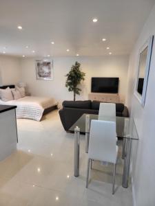 Beautiful One Bed Studio Flat في بريدجواتر: غرفة معيشة مع طاولة زجاجية وأريكة