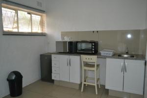 a small kitchen with a microwave and a sink at Bryanston Elgin - Cottage 2 in Johannesburg