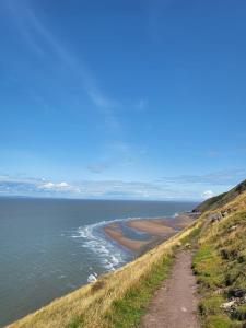 a dirt road on a hill next to the ocean at Beautiful One Bed Studio Flat - Dog Friendly in Bridgwater +5 photos