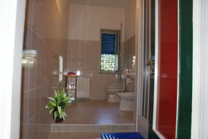 a bathroom with a toilet and a plant on the floor at Appartamento Astrea in Syracuse